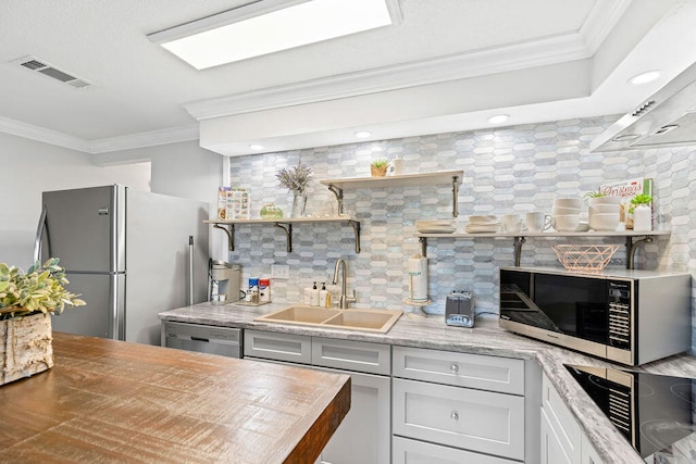 kitchen with backsplash, crown molding, stainless steel appliances, and sink