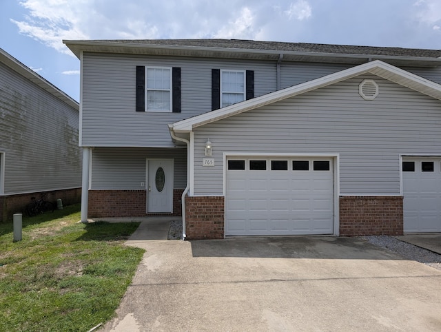 view of front of house featuring a garage, brick siding, and driveway