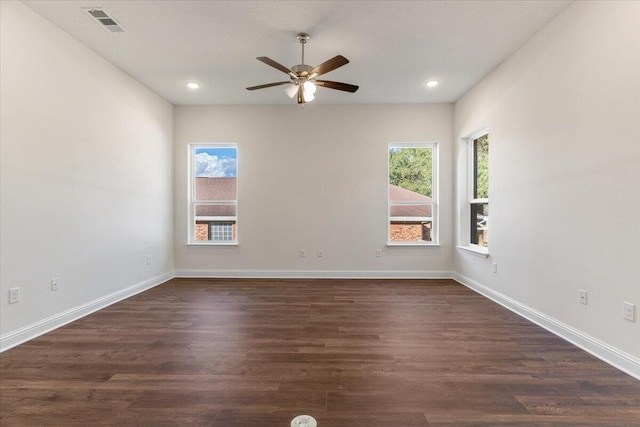 empty room featuring dark hardwood / wood-style floors, ceiling fan, and a healthy amount of sunlight