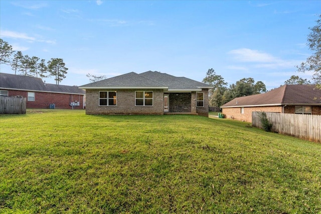 rear view of property featuring a lawn