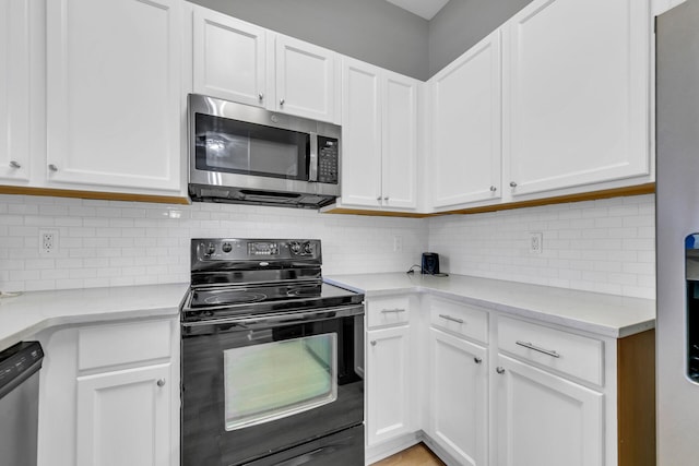 kitchen featuring stainless steel appliances, light stone countertops, and white cabinets