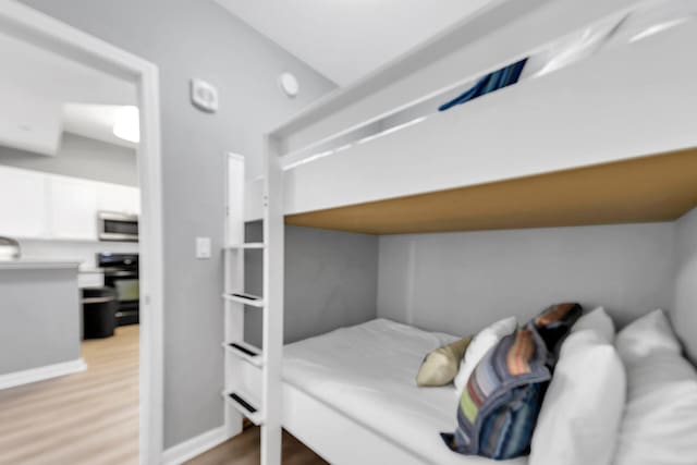 bedroom with light wood-style flooring and baseboards