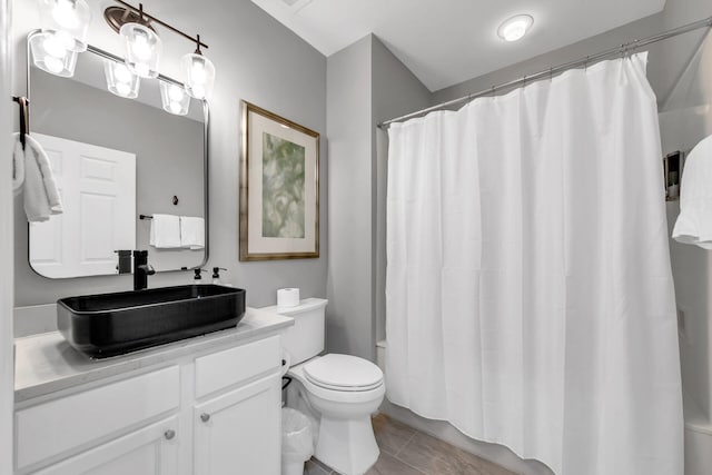 bathroom featuring shower / bath combination with curtain, tile patterned flooring, vanity, and toilet