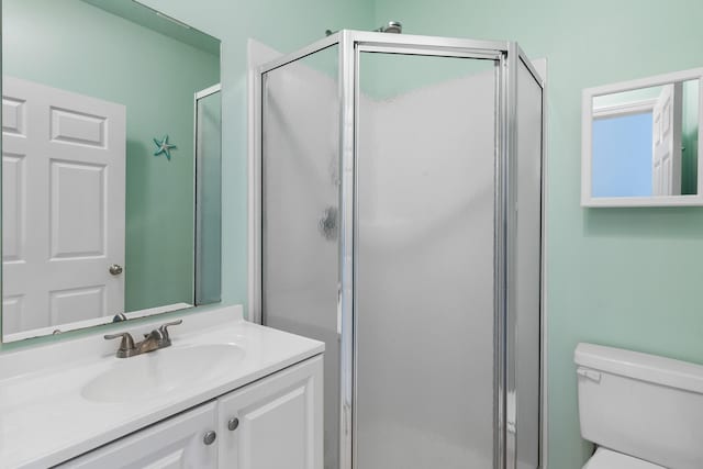 bathroom featuring walk in shower, toilet, and large vanity