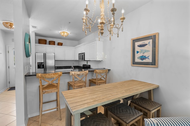 tiled dining area with sink and a notable chandelier