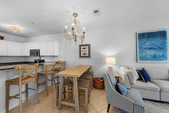 tiled dining area with a chandelier