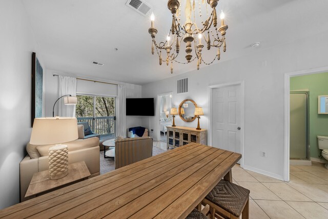 dining space featuring a notable chandelier and light tile floors