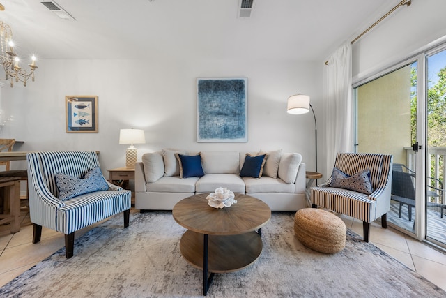 tiled living room with a notable chandelier