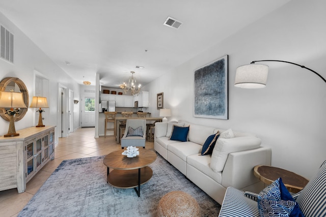 living room featuring a notable chandelier and light tile floors