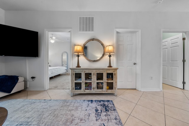 unfurnished living room featuring ceiling fan and light tile flooring