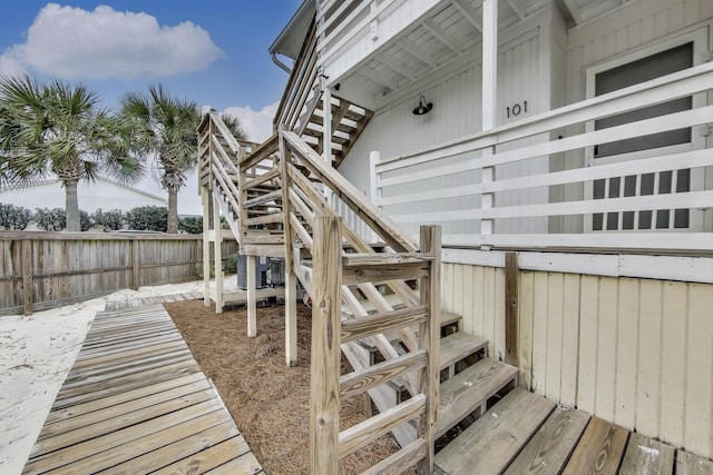 wooden terrace with stairs, central AC unit, and fence