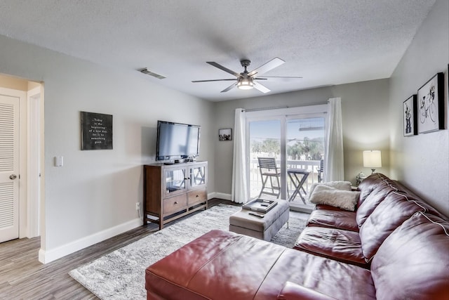 445 Gulf Shore Dr Unit 201, Destin, FL 32541 - living room featuring a ceiling fan, wood finished floors, baseboards, and a textured ceiling
