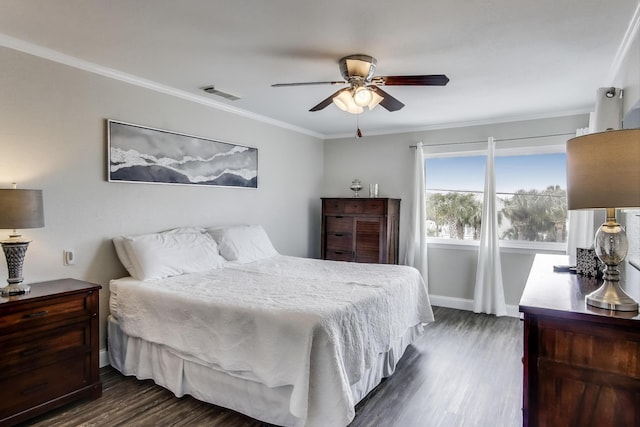 bedroom with dark wood-style flooring, visible vents, crown molding, and baseboards