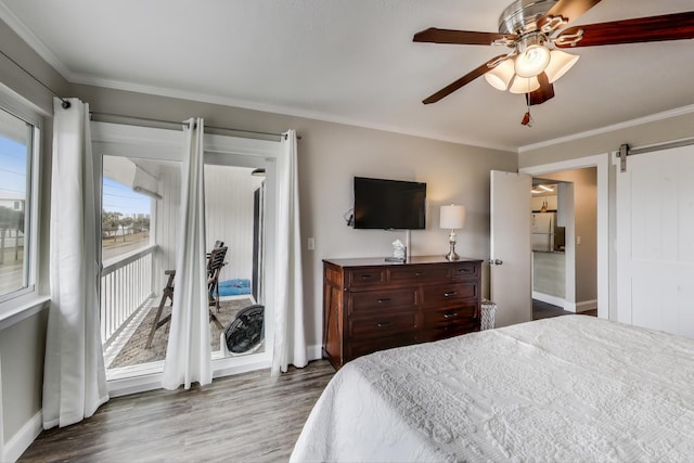 bedroom featuring a barn door, baseboards, ornamental molding, dark wood-style flooring, and access to exterior