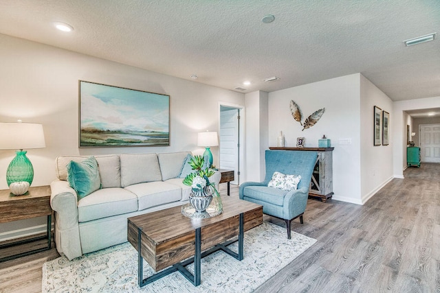 living room featuring a textured ceiling and light hardwood / wood-style floors