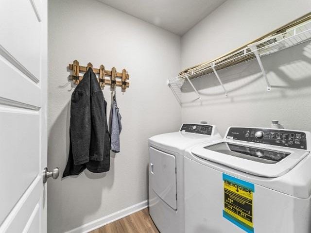 clothes washing area with wood-type flooring and separate washer and dryer