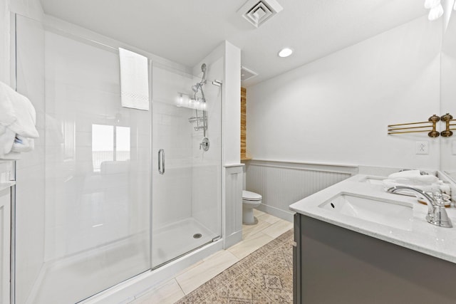 bathroom with a shower with shower door, toilet, tile flooring, and vanity