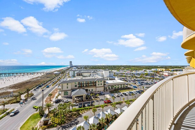 balcony with a water view and a view of the beach