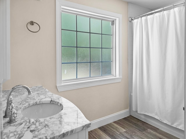 bathroom with wood-type flooring, vanity, and shower / tub combo