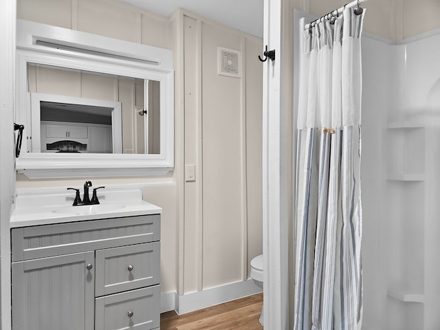 bathroom featuring toilet, vanity, and hardwood / wood-style flooring