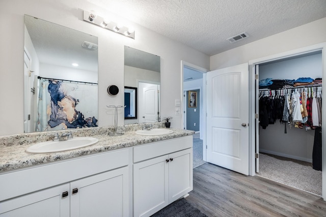 bathroom featuring vanity, a textured ceiling, and hardwood / wood-style flooring