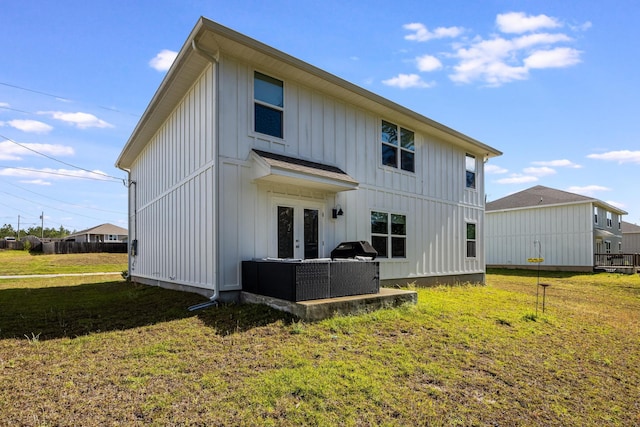 rear view of property featuring a lawn