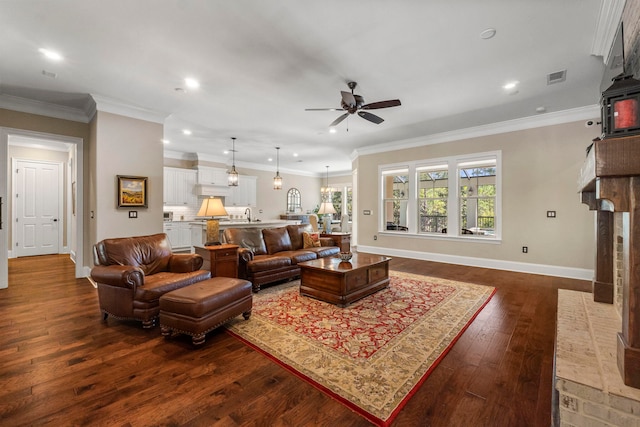 living room featuring ornamental molding, sink, ceiling fan, and dark wood-type flooring