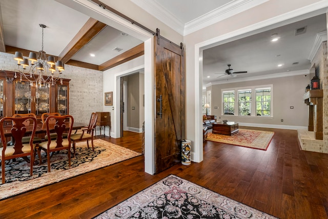 dining room with beamed ceiling, a barn door, ceiling fan with notable chandelier, crown molding, and dark hardwood / wood-style floors