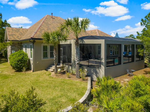 rear view of property with a yard and a sunroom