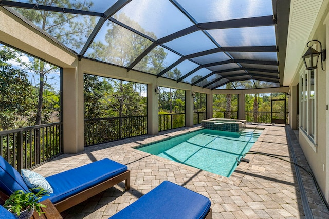 view of swimming pool featuring a patio area, an in ground hot tub, and glass enclosure