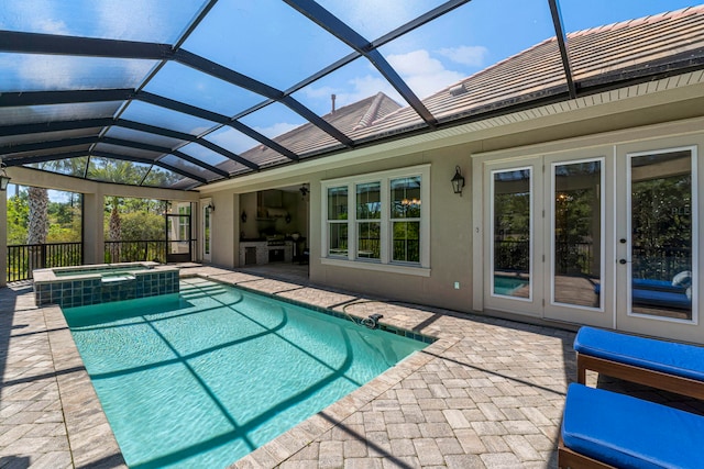 view of swimming pool with a patio, glass enclosure, an in ground hot tub, and french doors