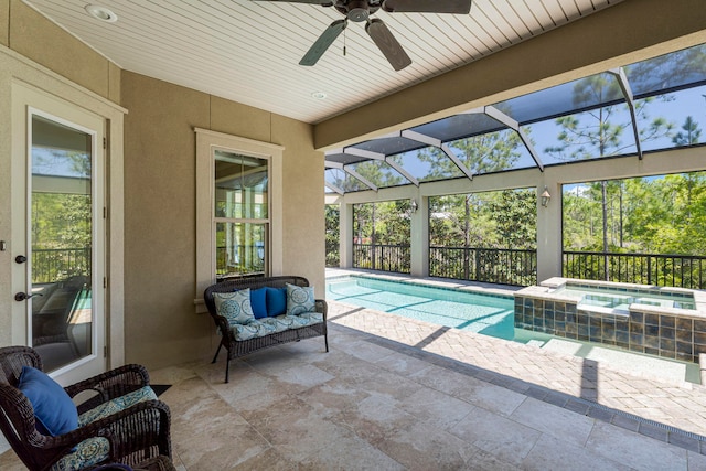 view of pool with glass enclosure, an in ground hot tub, outdoor lounge area, a patio area, and ceiling fan