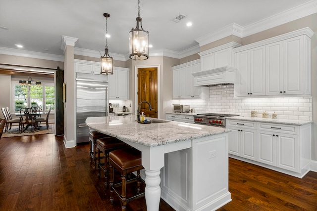 kitchen with white cabinetry, backsplash, dark wood-type flooring, a kitchen island with sink, and sink