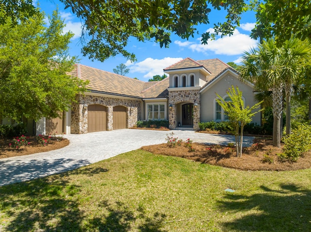 mediterranean / spanish home featuring a front lawn and a garage