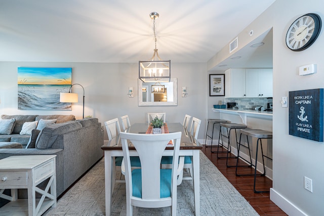 dining area with an inviting chandelier and hardwood / wood-style floors