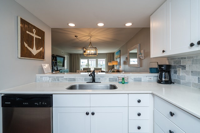 kitchen with decorative light fixtures, white cabinetry, kitchen peninsula, sink, and stainless steel dishwasher