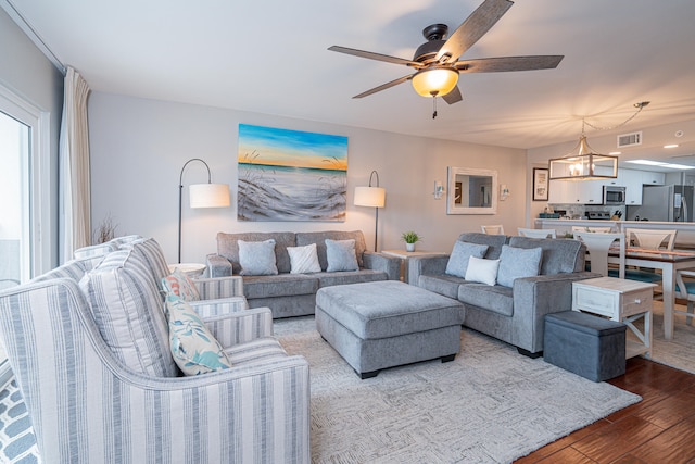 living room featuring ceiling fan and hardwood / wood-style flooring