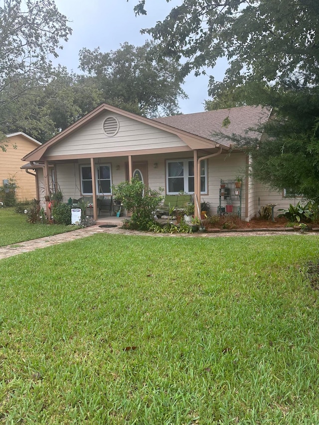 ranch-style house featuring a front yard and covered porch