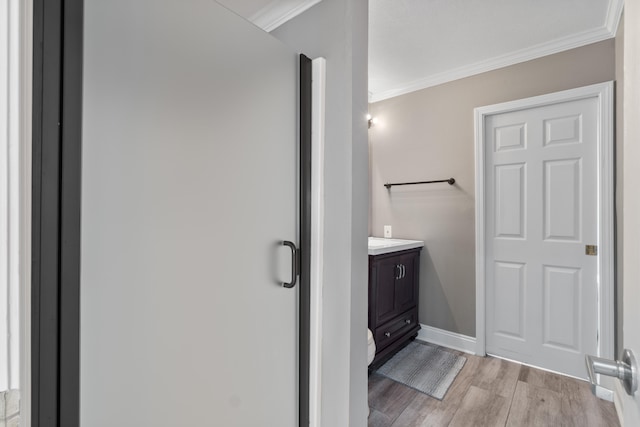 bathroom featuring hardwood / wood-style floors, vanity, and crown molding