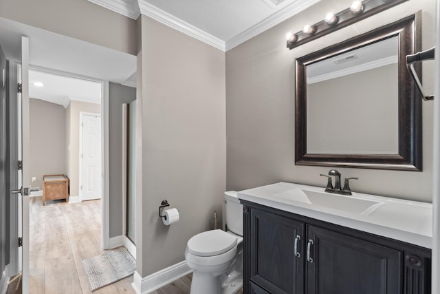 bathroom with hardwood / wood-style flooring, crown molding, toilet, and vanity