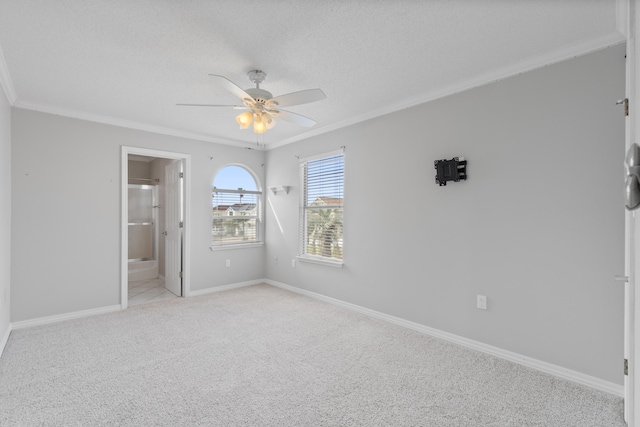 carpeted spare room featuring ceiling fan and crown molding