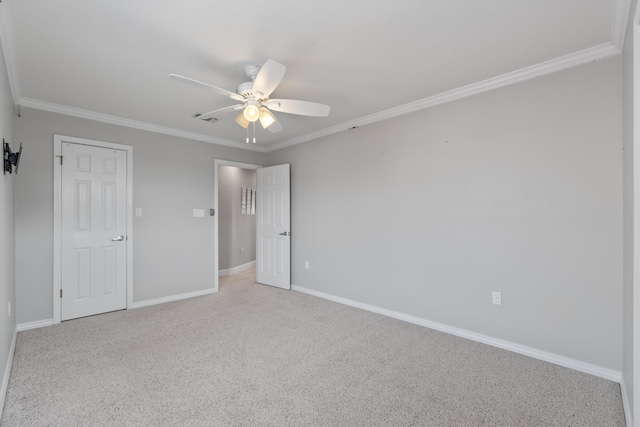 carpeted spare room with ceiling fan and crown molding