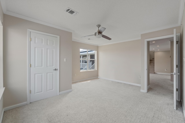 unfurnished bedroom with light colored carpet, ceiling fan, and crown molding