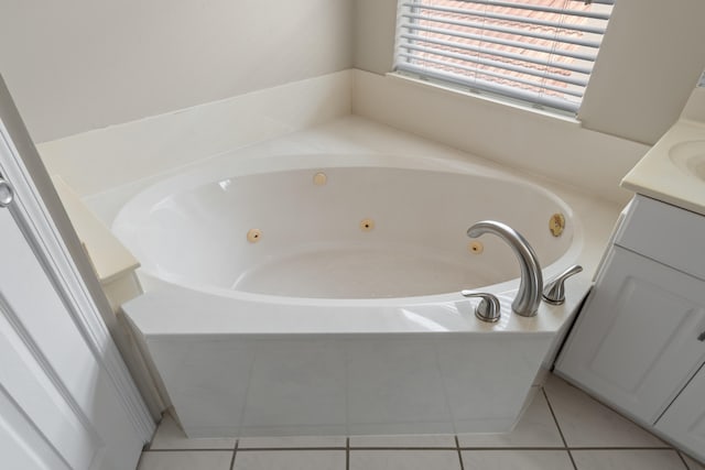 bathroom with a washtub, tile floors, and vanity