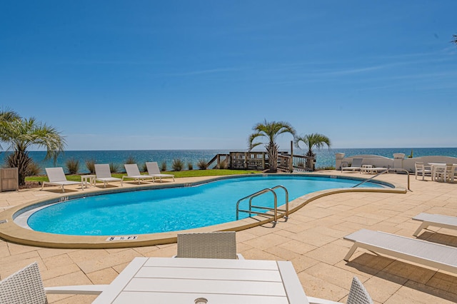 view of pool featuring a patio and a water view