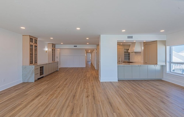 unfurnished living room with light hardwood / wood-style flooring and sink