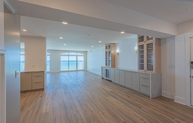 unfurnished living room featuring hardwood / wood-style floors and beverage cooler