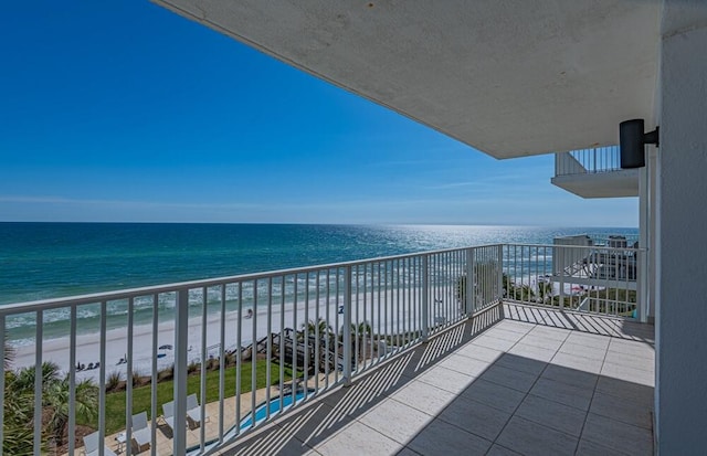 balcony featuring a water view and a beach view