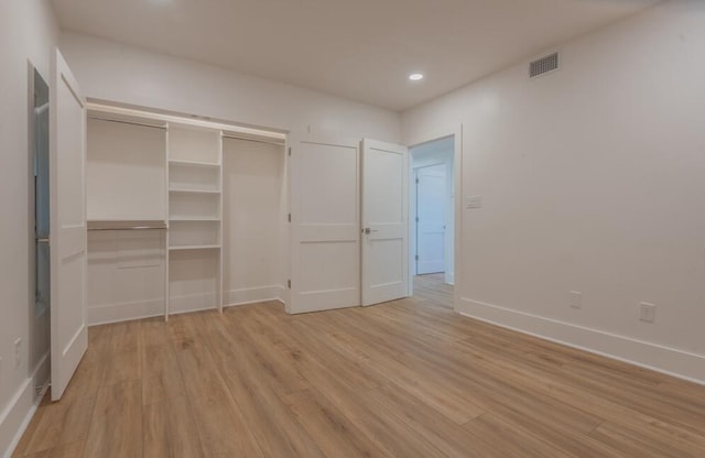 unfurnished bedroom featuring a closet and light wood-type flooring