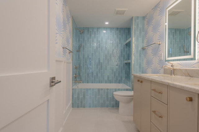 full bathroom featuring tile walls, tiled shower / bath combo, toilet, tile floors, and vanity